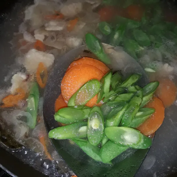 Tambahkan buncis dan wortel. Masak hingga air mendidih kembali.