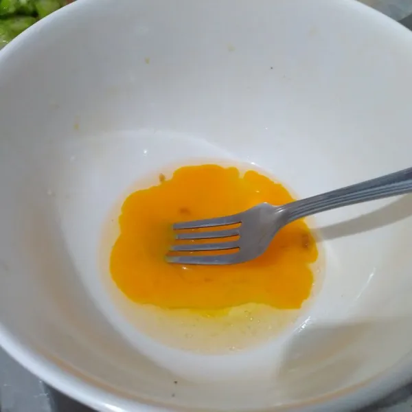 Kocok lepas dengan garpu telur dengan garam, merica, dan kaldu jamur