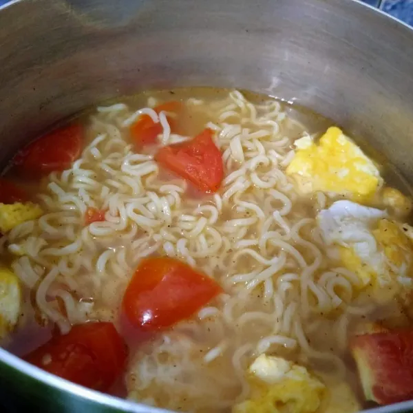 Terakhir masukkan mie rebus. Aduk rata. Angkat dan masukkan dalam mangkuk saji. Kucuri jeruk purut. Taburi bawang goreng. Mie rebus telor dengan tomat siap disajikan.