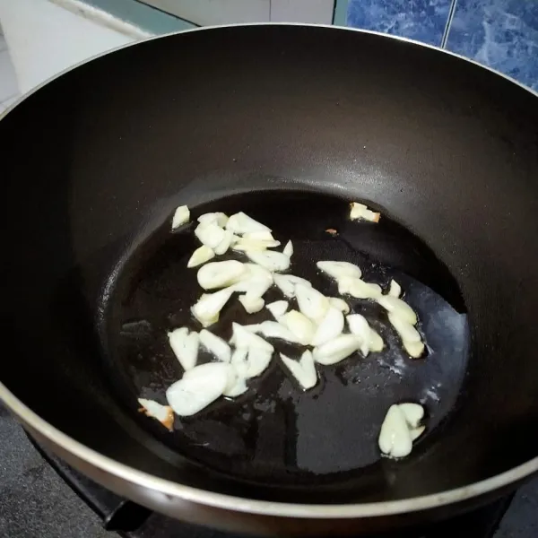 Tumis bawang putih hingga layu dan harum.