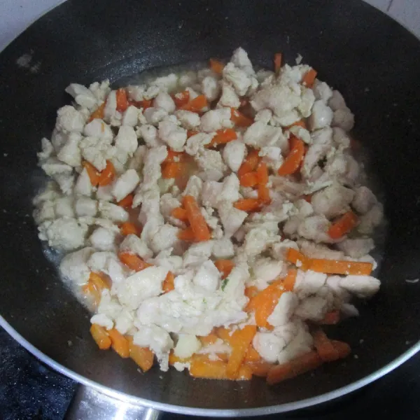 Tuang air. Masukkan wortel. Masak hingga ayam dan wortel hampir matang.