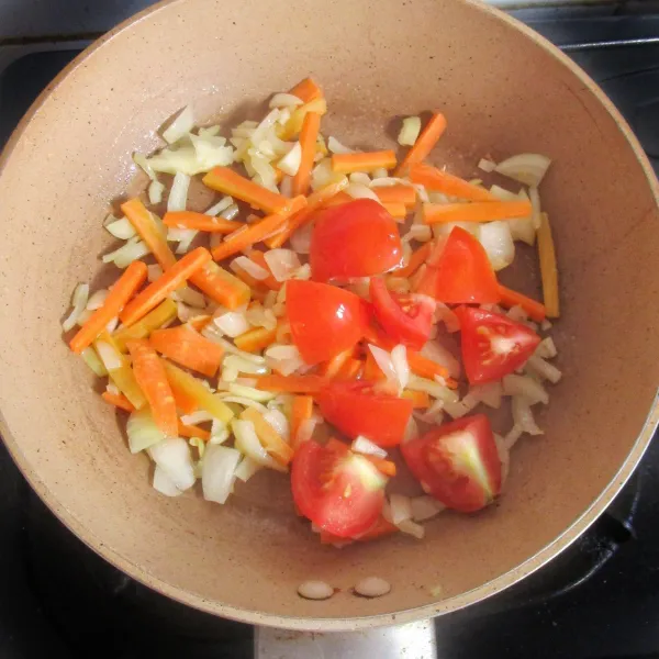 Membuat saus asam manis: panaskan minyak secukupnya. Tumis bawang bombai dan bawang putih hingga harum. Masukkan  wortel yang diiris korek api dan irisan tomat.