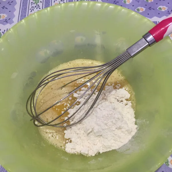 Masukkan 3 sdm tepung terigu ke dalam adonan telur dan gula lalu aduk hingga tepung tidak ada yang menggumpal.