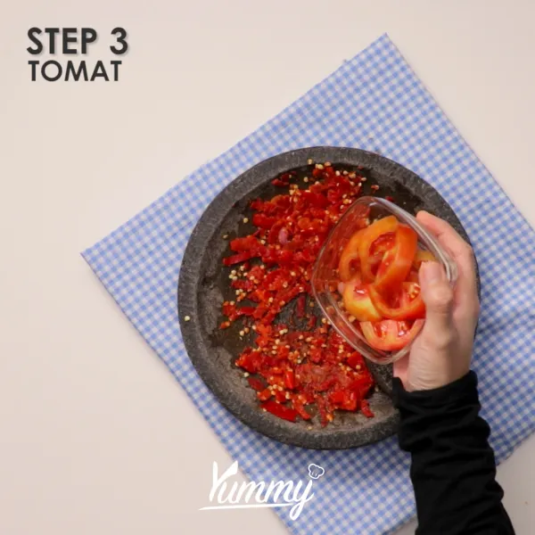 Tambahkan tomat dan terasi bakar, ulek kembali hingga sambal berair.