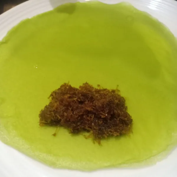Ambil 1 sdt unti kelapa, lalu lipat dan gulung dengan rapi di atas adonan lumpia. Dadar gulung pandan siap disajikan.