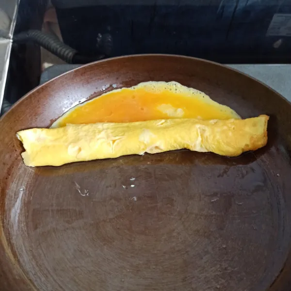 Goreng telur di panci dengan minyak panas, lalu perlahan membentuk persegi panjang menggunakan spatula. Bisa menggunakan teknik menggoreng telur omelette