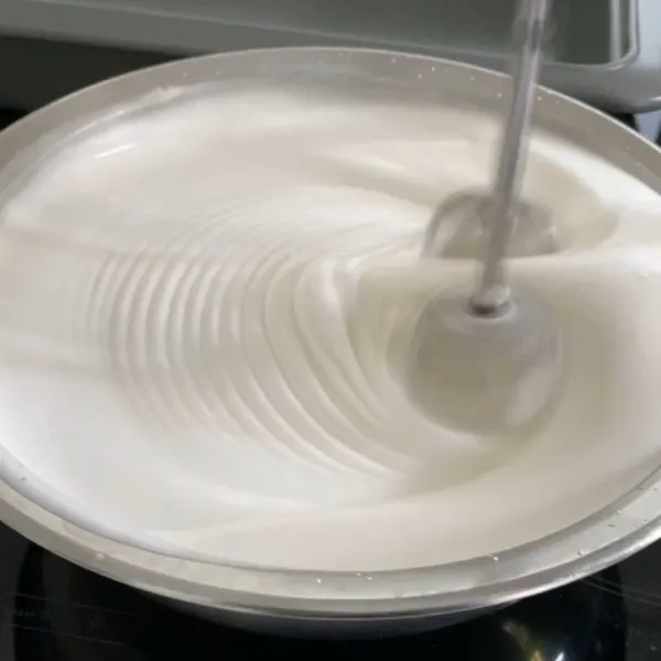 Whisk menggunakan mixer, aduk putih telur dan gula hingga kaku dan tercampur rata.