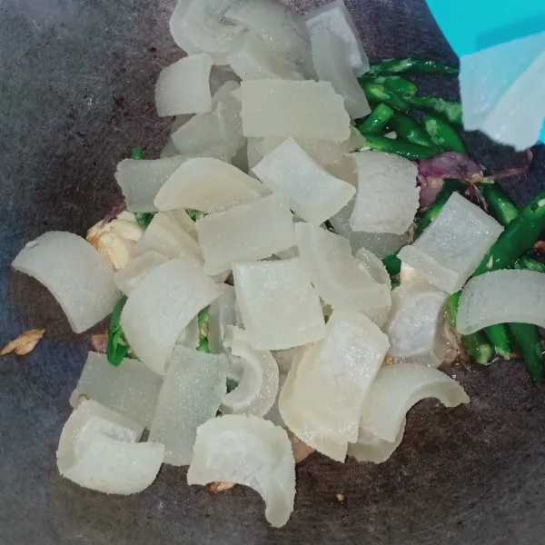Tumis bawang merah, bawang putih, cabai hijau hingga harum lalu masukkan kikil yang sudah dipotong-potong.