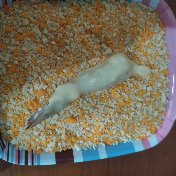 Celupkan ke bahan pencelup basah kemudian gulingkan di tepung roti, gulingkan sambil ditekan-tekan, lakukan sampai udang habis.