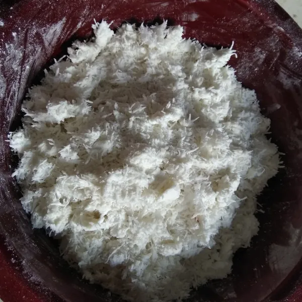 Uleni tepung ketan dengan kelapa parut.