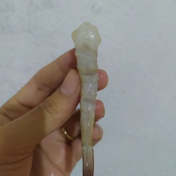 Kupas udang sisakan ekornya, belah sedikit punggung udang lalu tarik bagian yang menyerupai benang hitam, berihkan pula yang terdapat di bagian perut. Sayat udang pada bagian perut di tiga titik, tapi jangan sampai putus.