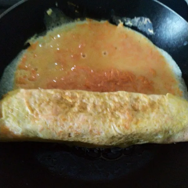 Geser Tamagoyaki, tuang kembali adonan pada ujung Tamagoyaki, tunggu set jemudian gulung kembali, lakukan proses tersebut sampai adonan habis.