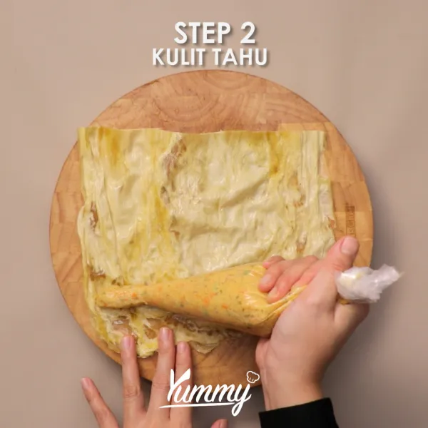 Siapkan kulit tahu yang sudah direndam ke dalam air sebentar, masukkan bahan isian, kemudian gulung.