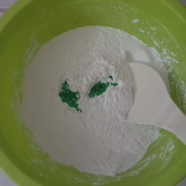 Tuang air panas yang sudah diberi pasta pandan ke dalam tepung secara bertahap