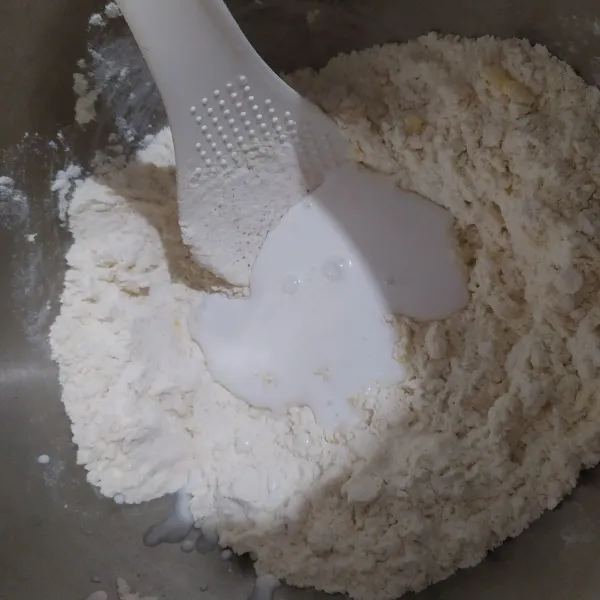 Lalu masukkan air  bertahap sambil terus diuleni dengan tangan, stop jika adonan sudah dirasa cukup ( bisa menggumpal tapi tidak lembek ) tambahkan jika dirasa kering.