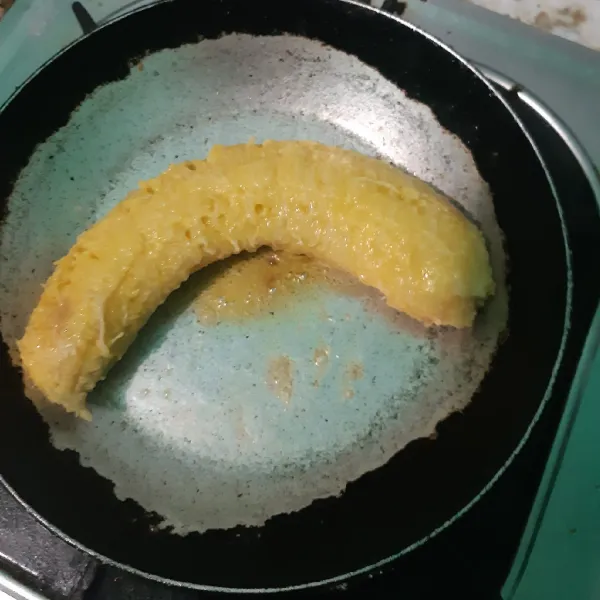 Kupas 1 buah pisang lalu panggang di atas teflon yang sudah diolesi dengan margarin, panggang kira kira 10 menit dibolak balik.