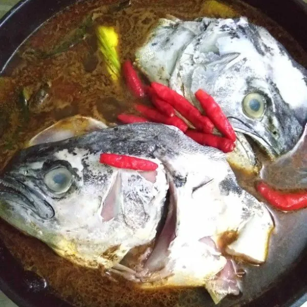 Kemudian masukkan kepala ikan dan cabai rawit utuh, masak sampai kepala ikan matang.