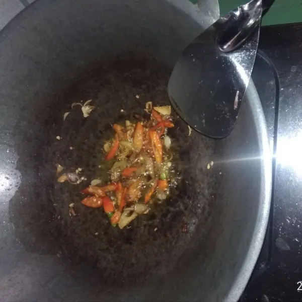 Panaskan wajan dan minyak goreng. Tumis irisan bawang merah dan bawang putih sampai harum. Masukan irisan cabe rawit lalu tumis lagi sampai layu.