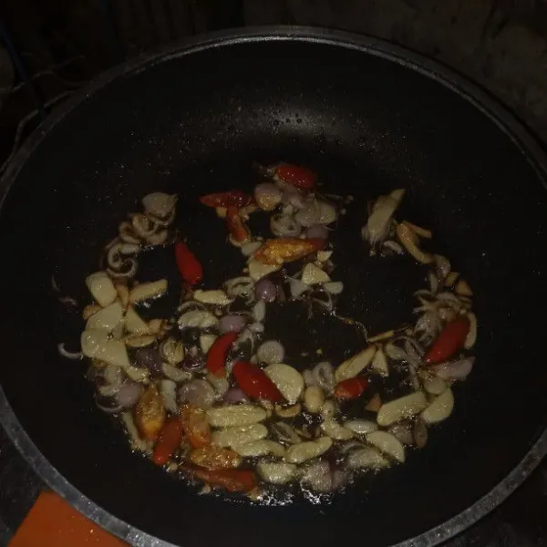 Siapkan pan, masukkan minyak goreng lalu panaskan, kemudian tumis bawang putih, bawang merah, dan cabai rawit sampai wangi
