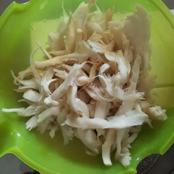 Suir-suir jamur tiram, kemudian cuci bersih dan peras sampai tidak ada airnya