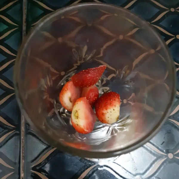 Potong-potong buah strawberry lalu masukan kedalam gelas.