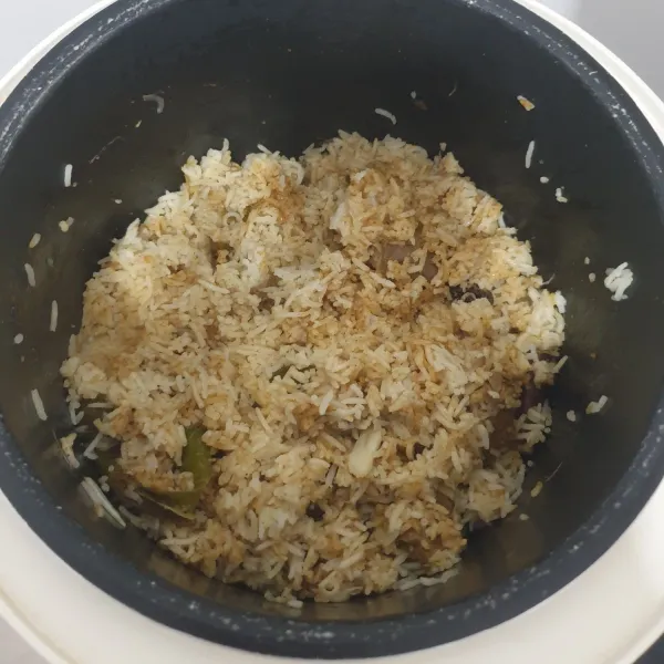 Setelah nasi matang biarkan dalam rice cooker selama 10 menit, kemudian buka dan aduk perlahan. Sajikan mau Beriani Kambing Muda dengan acar dan irisan daun ketumbar.