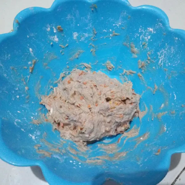 Masukkan tepung tapioka, tepung terigu, wortel, dan daun prei. Uleni dengan tangan hingga adonan tercampur rata. Tes rasa.