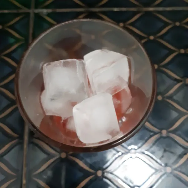Tambahkan potongan es batu hingga penuh  kedalam gelas.