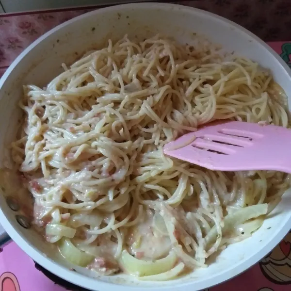 Tuang spaghetti lalu aduk sebentar hingga rata. Angkat dan siap disajikan dengan parutan keju atau chili flakes.