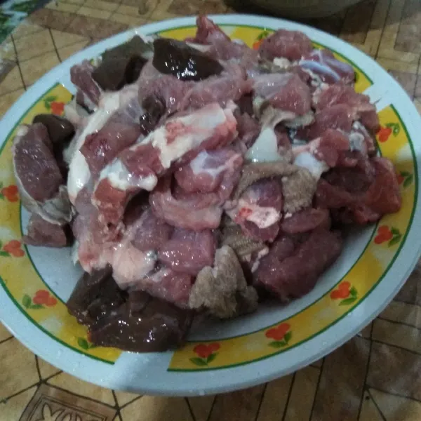 Potong daging dan jeroan kambing sesuai selera.