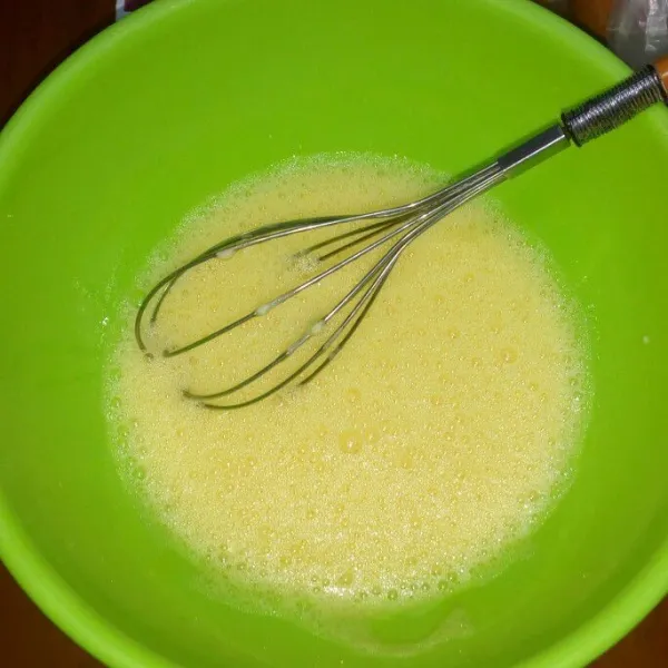 Di wadah terpisah kocok telur dan gula sampai gula larut.