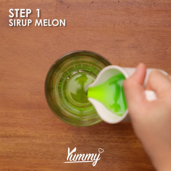 Siapkan gelas saji, tambahkan sirup melon dan buah melon.