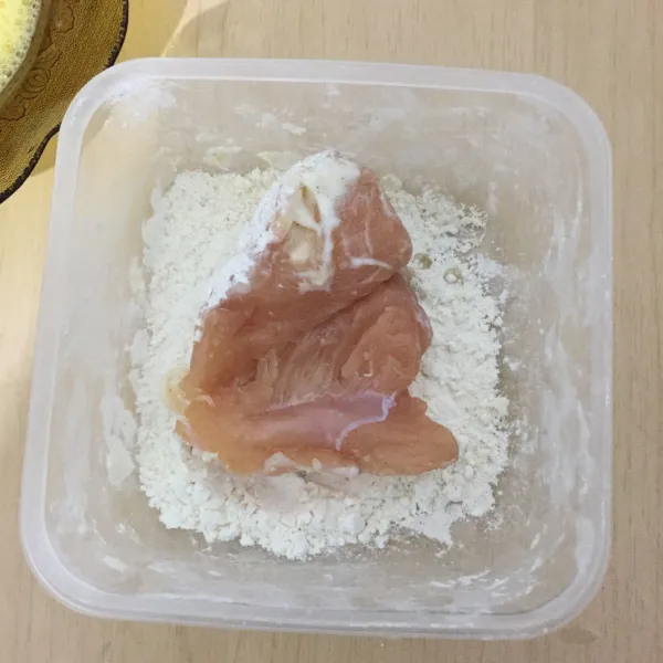 Lumuri ayam yang sudah dimarinasi dengan tepung terigu.