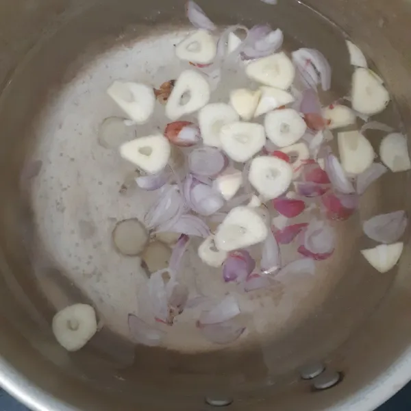 Panaskan air di dalam panci. Masukkan bawang merah, bawang putih dan kencur. Masak hingga mendidih.