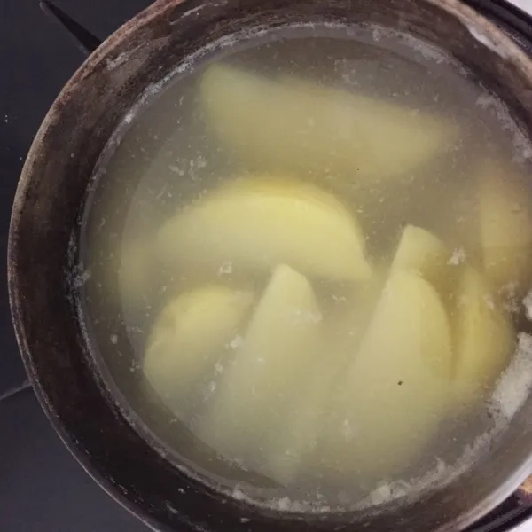Potong kentang menjadi 8 bagian, kemudian rebus selama 5 menit.