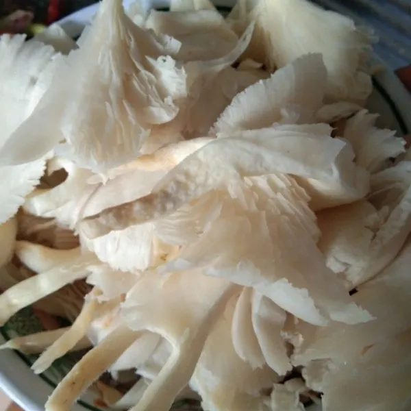 Tiriskan jamur tiram, sobek jamur tiram menjadi 2 bagian, sisihkan.
