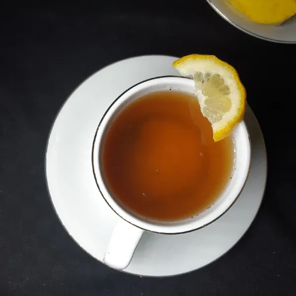 Tuang teh ke dalam gelas. Aduk sampai rata. Lemon tea hangat pun siap dihidangkan.