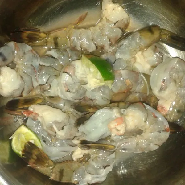 Belah punggung udang lalu buang kotorannya. Kucuri dengan secukupnya air perasan jeruk nipis. Diamkan 10 mnt, cuci bersih.
