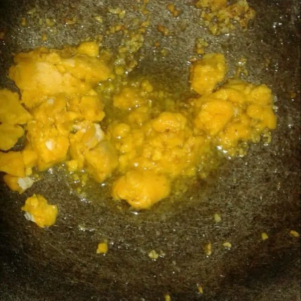 Masukkan kuning telur asin dan bubuk bawang putih. Aduk rata.