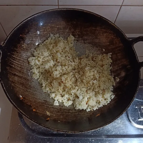 Masukkan nasi. Tambahkan bumbu-bumbu dapur. Aduk hingga rata.