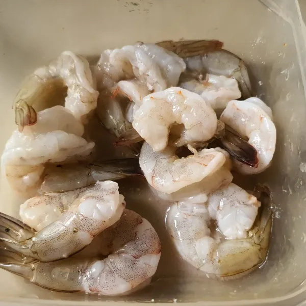 Bersihkan Udang. Buang Kotoran dan kepalanya. Belah bagian punggungnya. Lumuri garam dan air perasan jeruk nipis.