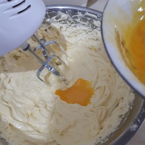 Masukkan kuning telur satu persatu dengan kecepatan rendah. Setelah tercampur dengan baik, masukkan campuran terigu dan spekuk sambil diayak. Jangan overmix. Matikan mixer, sisihkan.