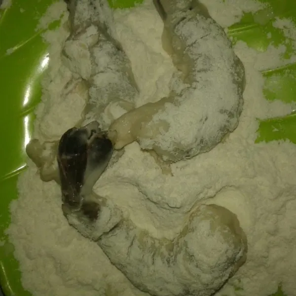 Gulingkan udang di tepung pelapis kering sampai rata.