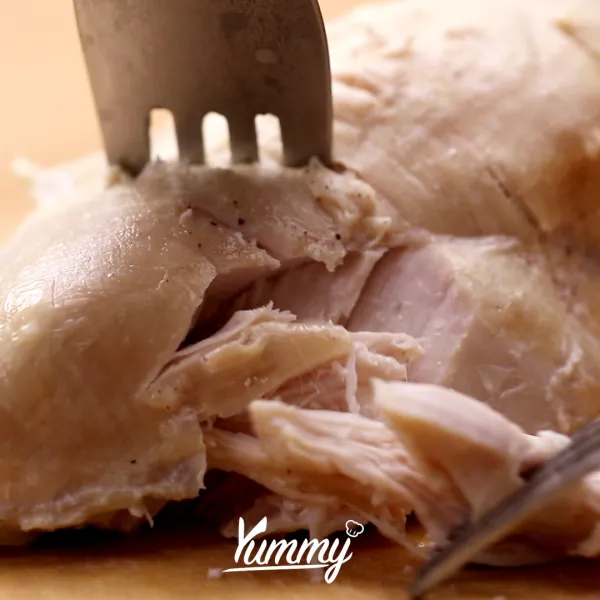 Suwir-suwir ayam dengan bantuan garpu, terutama ketika ayam masih hangat karena akan mempermudah proses.