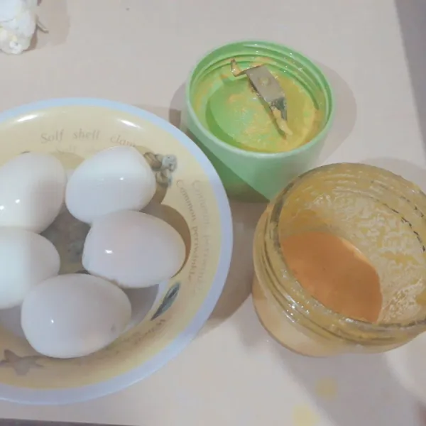 Rebus & kupas telur. Haluskan bawang putih, kunyit & kemiri.
