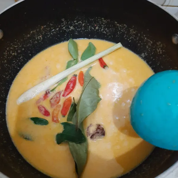 Masukkan santan, serai, cabai rawit, dan daun jeruk. Aduk rata