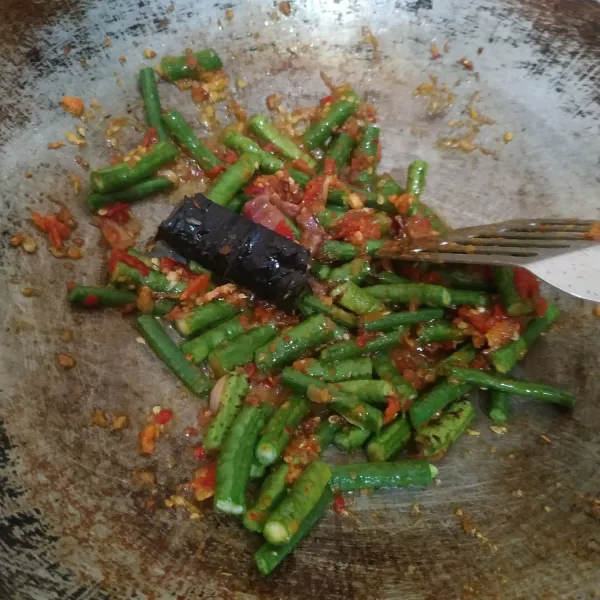 Masukkan kacang panjang, aduk rata. Masak sampai setengah matang