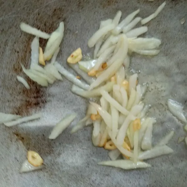 Tumis bawang putih hingga berubah warna kemudian masukkan bawang bombay. Tumis hingga layu.