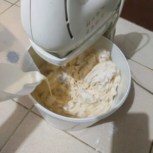 Campurkan biang yang sudah kita buat tadi (saya sarankan dipotong kecil-kecil supaya mudah ketika diaduk) dan diselingi dengan susu yang dituang sedikit demi sedikit hingga setengah kalis dulu.