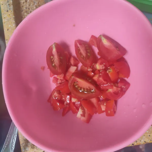 Potong-potong tomat ukuran kecil dan besar sesuai selera.